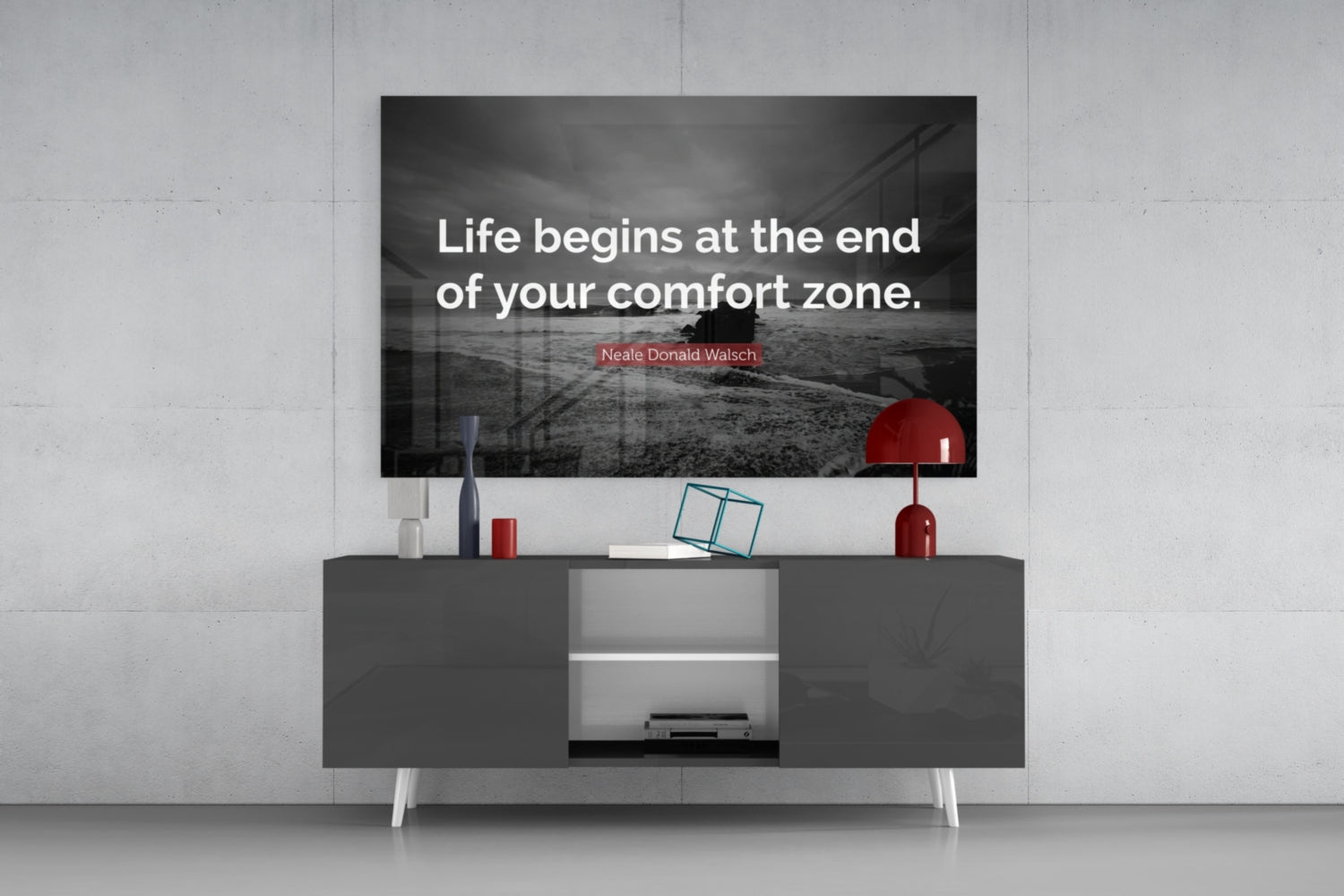 Glass wall art displaying motivational quote "Life begins at the end of your comfort zone" mounted above modern media console.