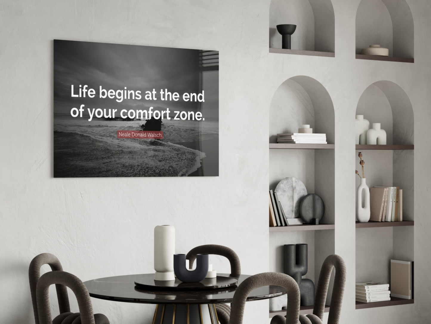 Modern dining room with black glass wall art displaying Neale Donald Walsch quote above round table and chairs.