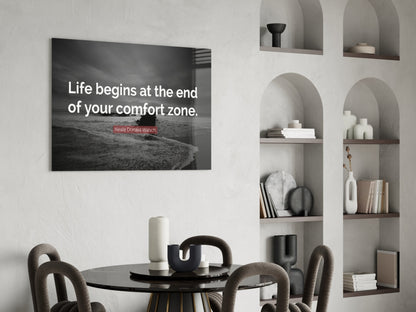 Modern dining room with black glass wall art displaying Neale Donald Walsch quote above round table and chairs.