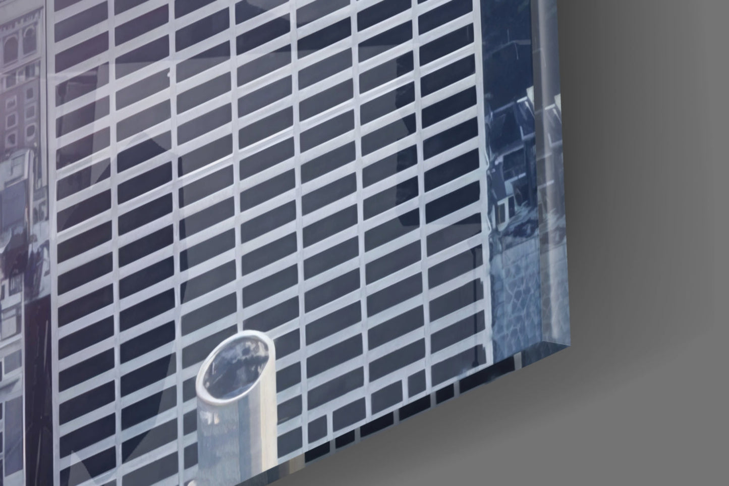 Glass wall art panel displaying modern skyscraper with white and dark horizontal stripes in perspective view.
