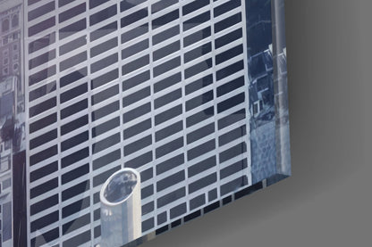 Glass wall art panel displaying modern skyscraper with white and dark horizontal stripes in perspective view.
