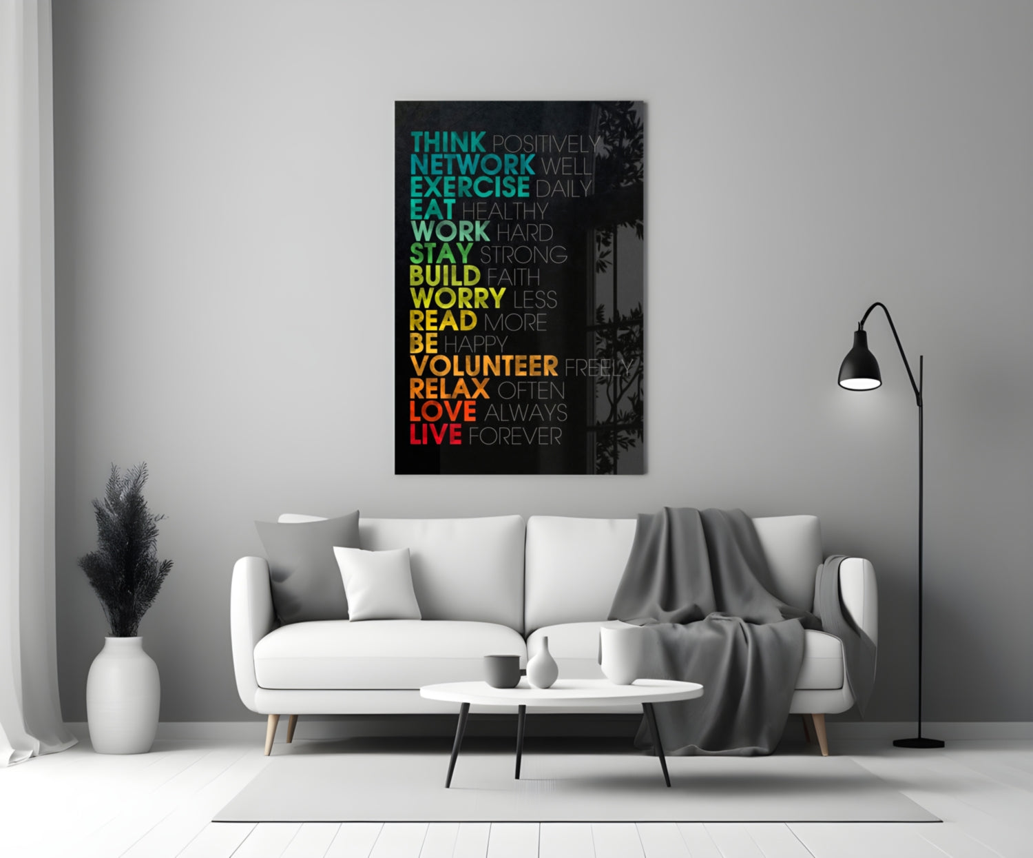 Colorful motivational glass wall art with gradient text from teal to red displayed above a white sofa in a modern living room.
