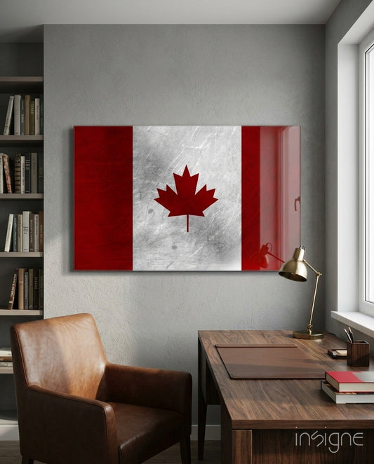 Scratched metal Canadian flag glass wall art displayed above a wooden desk in a modern office setting with leather chair and bookshelf.