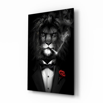 Angled front view of black and white glass wall art showing a lion in formal tuxedo with bow tie, cigarette, and red rose boutonnière against dark background.
