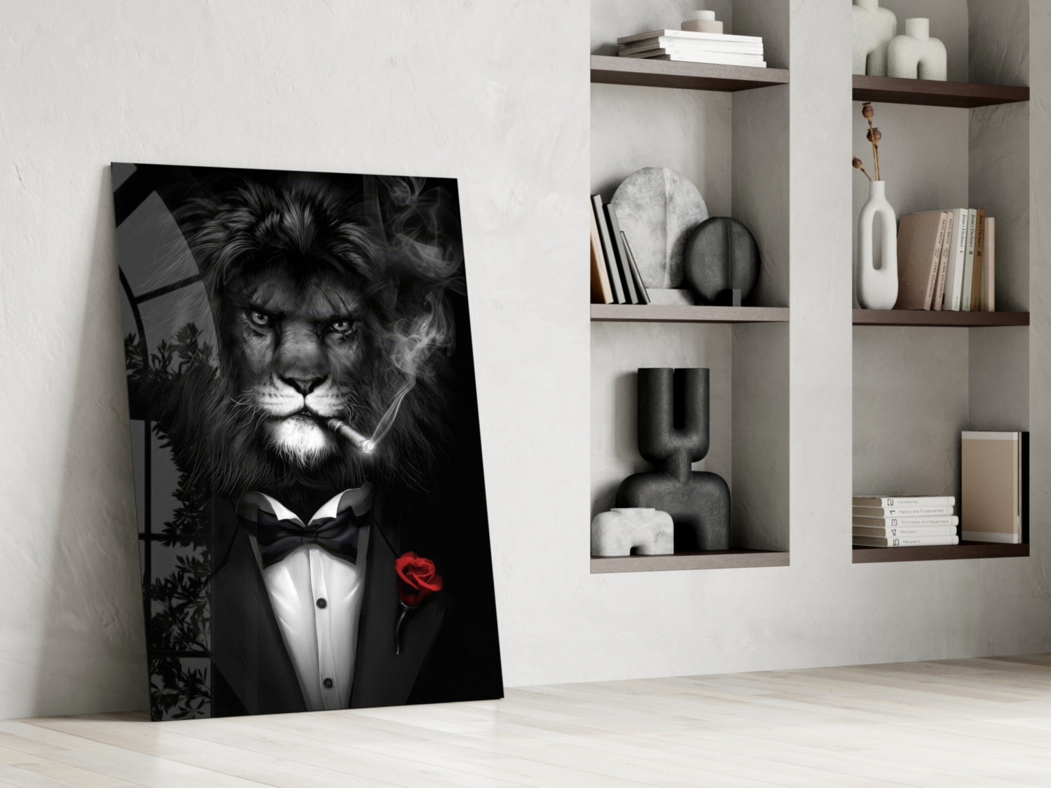 Black and white glass wall art of a lion in formal tuxedo with red rose, leaning against white wall beside built-in shelving with books and decorative objects.