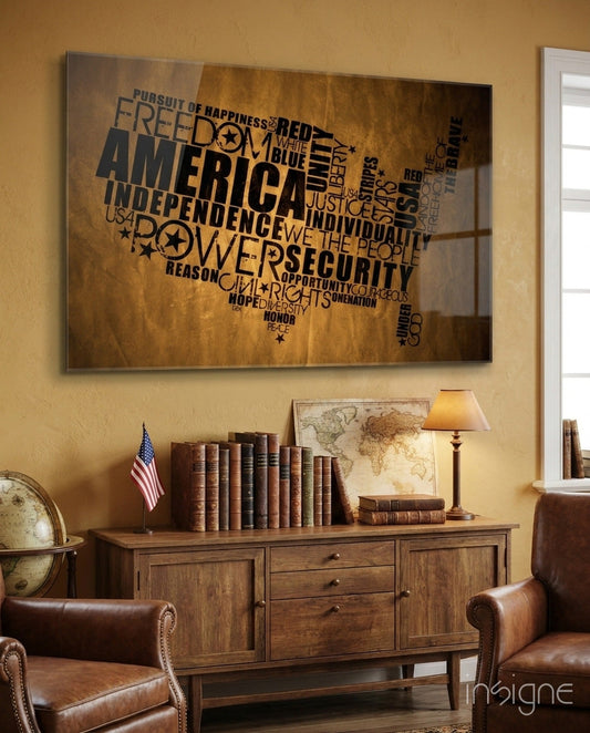 USA map glass wall art with black text displaying American values displayed above wooden cabinet in gold-toned study room.