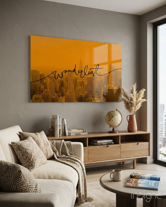 Amber Sunset Skyline Wanderlust Glass Wall Art displayed above wooden console table in modern living room with cream chair and travel-themed decor.