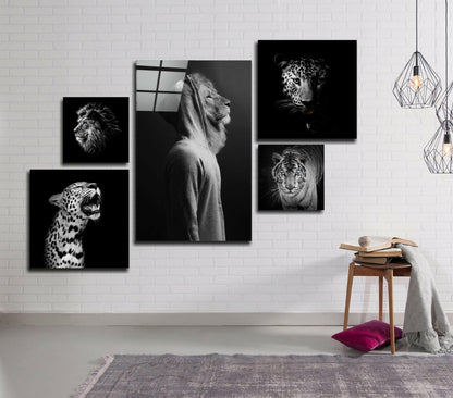 Black and white glass wall art gallery featuring five animal portraits—lion, leopard, and tiger—arranged asymmetrically on white brick.