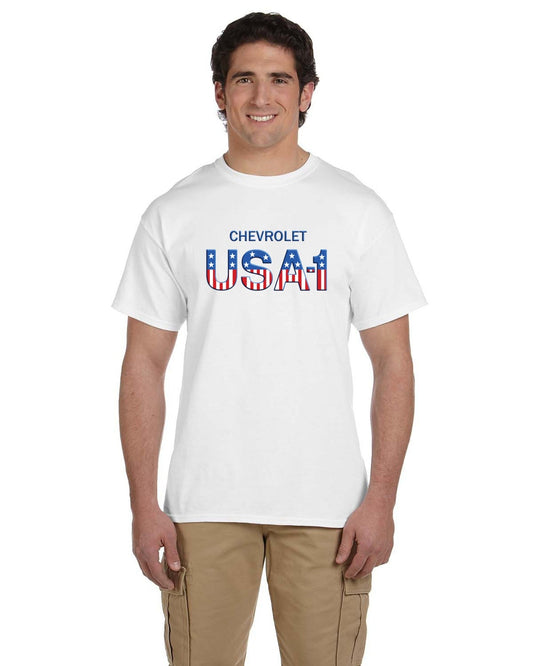 Front view of a smiling man in a white crew-neck t-shirt with blue CHEVROLET and star-striped USA-1 lettering.
