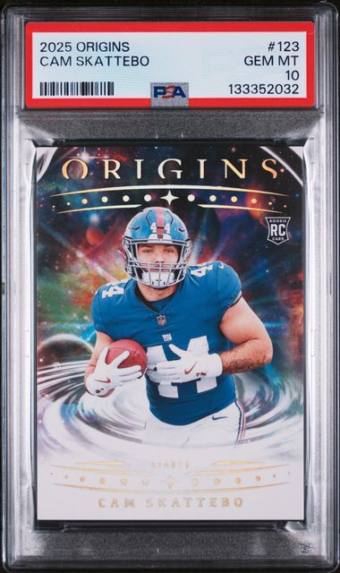 PSA-graded rookie football card in plastic holder showing Cam Skattebo in blue uniform catching ball, with "Origins" header and holographic background design.