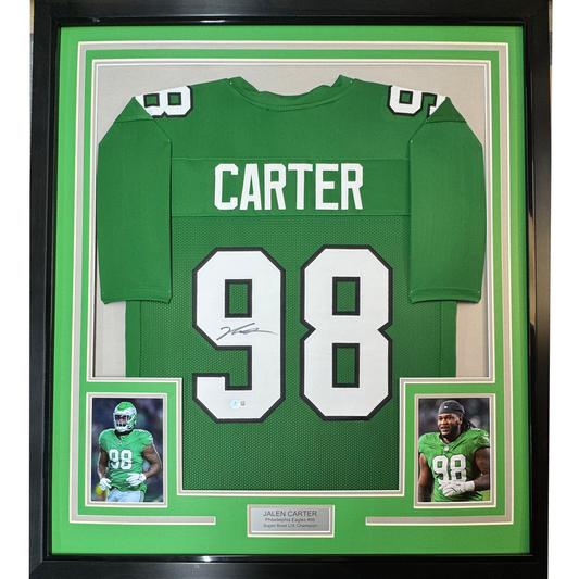 Framed green Philadelphia Eagles #98 Carter jersey with autographed numbers, flanked by two player photographs on green matting with black frame.