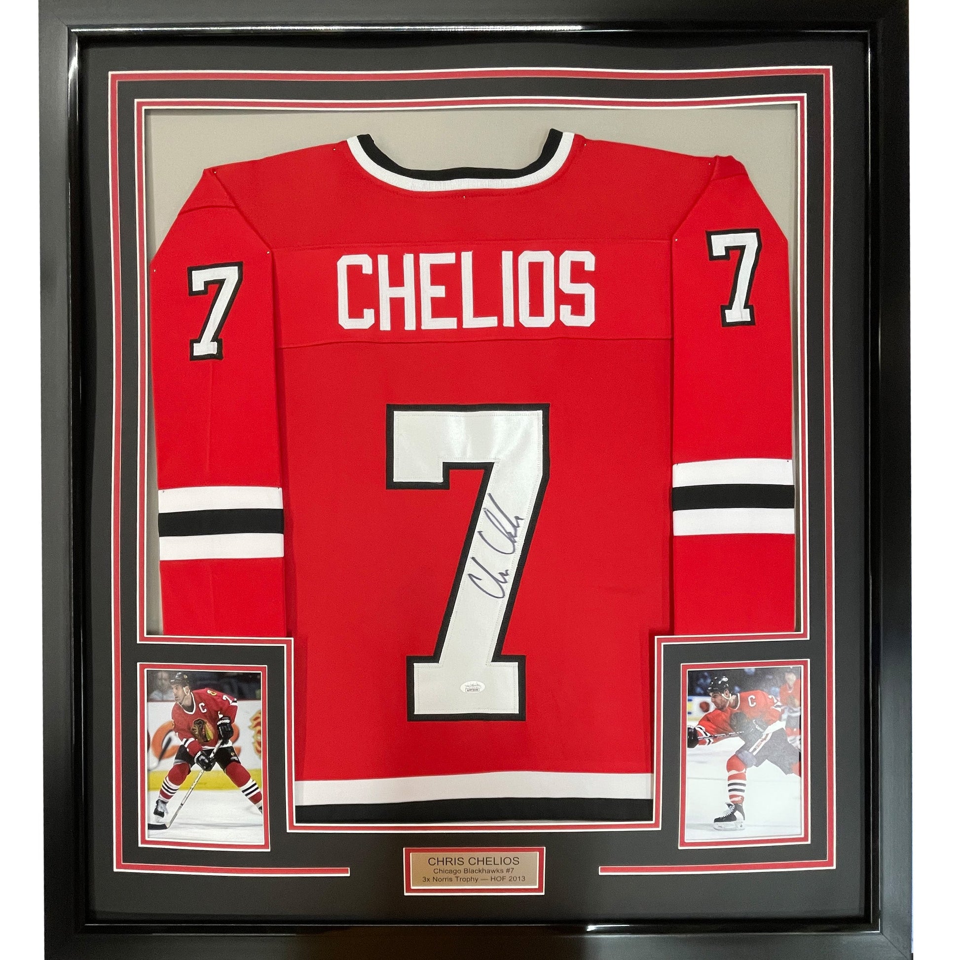 Framed red Chicago Blackhawks hockey jersey number 7 signed by Chris Chelios, displayed flat with two photographs and nameplate below.