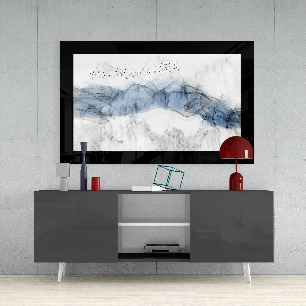 Blue Nebula Glass Wall Art displayed in black frame above gray media console with red lamp and decorative accessories.