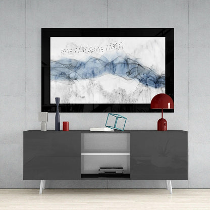 Blue Nebula Glass Wall Art displayed in black frame above gray media console with red lamp and decorative accessories.