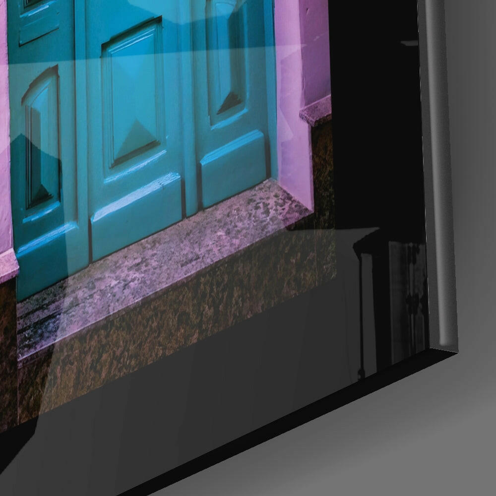 Angled view of glass wall art displaying a turquoise door with pink and purple atmospheric lighting effects.