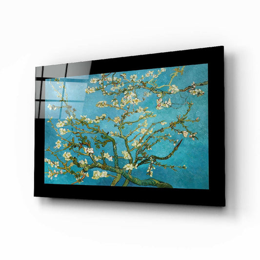 Black-framed glass wall art displaying Van Gogh's almond blossoms painting mounted at an angle against white background.
