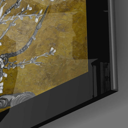 Close-up detail of gold glass wall art with white and gray painted almond flowers and branches against textured golden background.