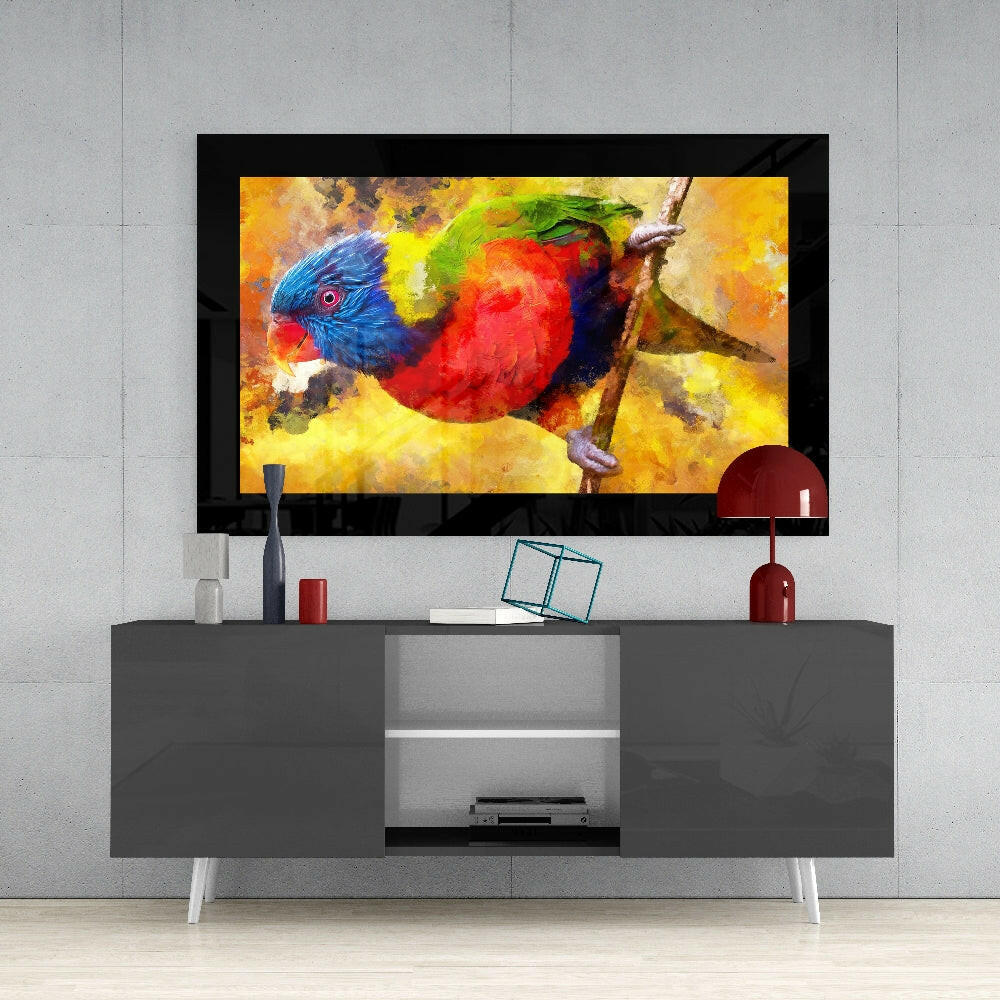 Framed tropical parrot glass wall art displaying vibrant red, blue, and yellow plumage mounted above a gray media console.