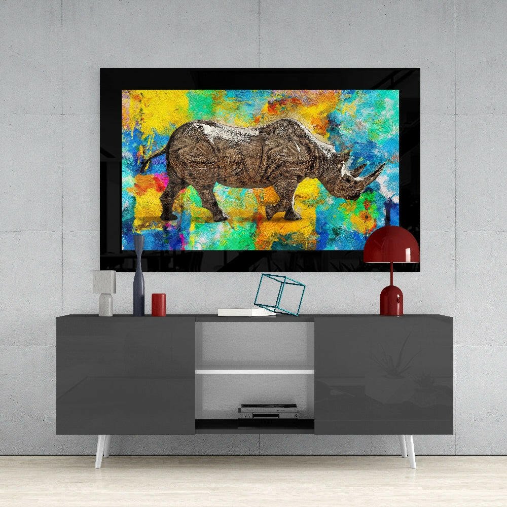 Colored Rhinoceros Glass Wall Art displayed above a gray media console against a concrete wall, showing vibrant multicolored abstract background with detailed rhinoceros illustration.