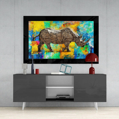 Colored Rhinoceros Glass Wall Art displayed above a gray media console against a concrete wall, showing vibrant multicolored abstract background with detailed rhinoceros illustration.