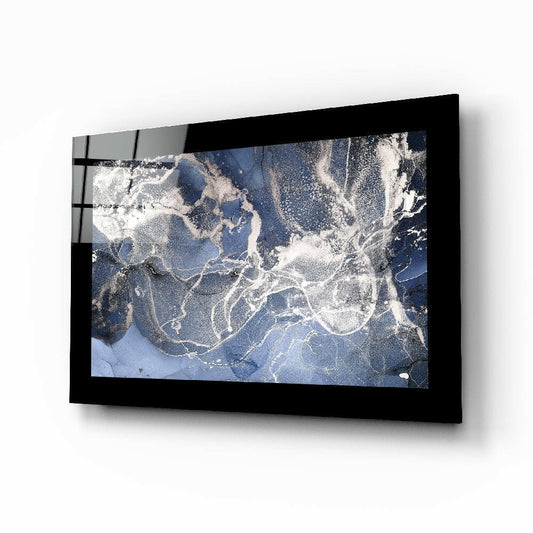 Black-framed blue quartz glass wall art mounted on white wall, displaying satellite or aerial map view with white cloud patterns and blue water.