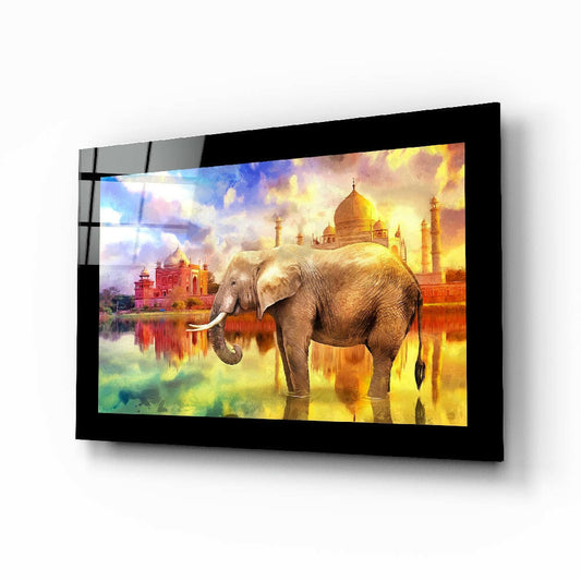 Angled perspective of framed glass wall art displaying an elephant with golden dome architecture and colorful water reflection against warm sky backdrop.