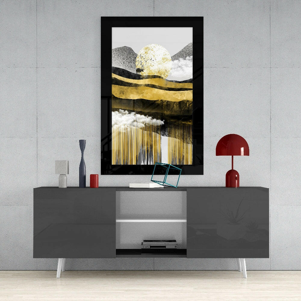 Black-framed glass wall art with gold leaf and white cloud design displayed above gray media console with red accents.