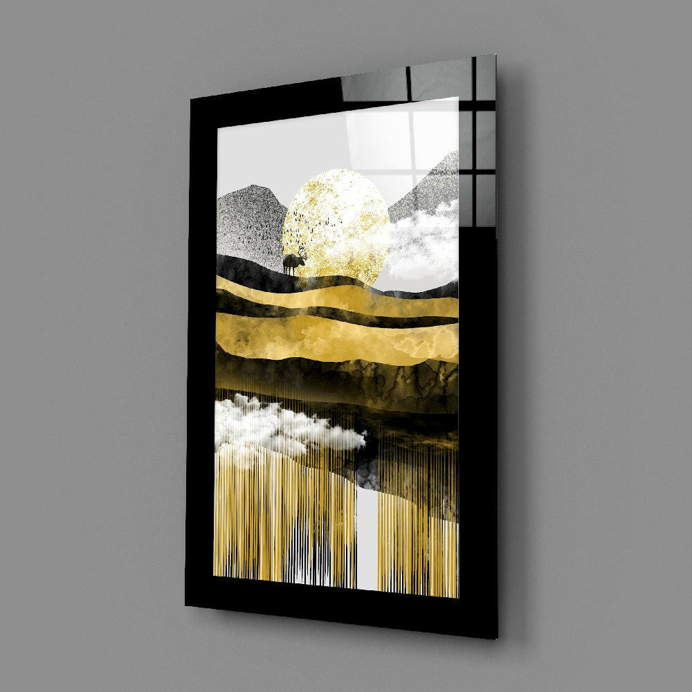 Black-framed glass wall art displaying abstract landscape with gold, gray, and white layers, small silhouette figure, and vertical line texture, angled perspective view.