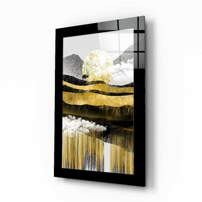 Black-framed glass wall art displaying an abstract landscape with gold leaf, mountains, and a silhouetted tree against textured gray and white layers.