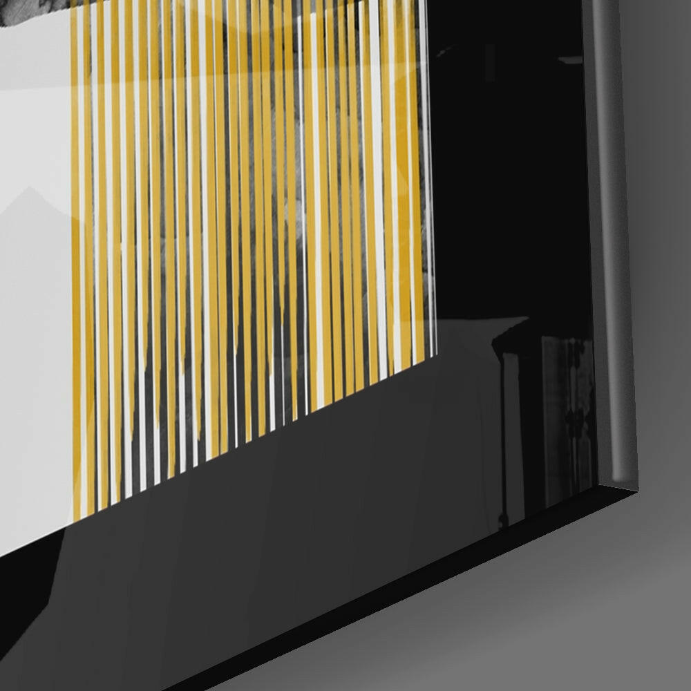 Close-up angled view of golden vertical line pattern glass panel mounted on black base against white wall.