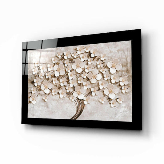 Black-framed glass wall art displaying white and beige flowers on a textured stone-colored background, mounted at an angle.