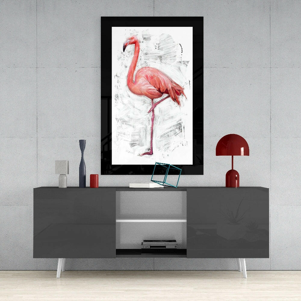 Framed flamingo art print displayed above a gray media console with red lamp and decorative accessories against concrete wall.