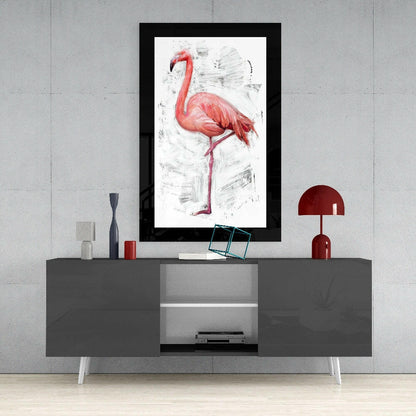 Framed flamingo art print displayed above a gray media console with red lamp and decorative accessories against concrete wall.