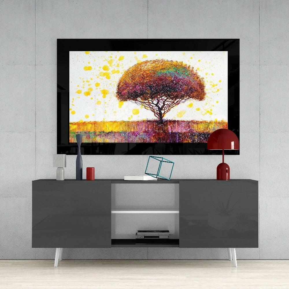 Framed colorful tree artwork with yellow splashes displayed above gray media console with red accents and decorative items.