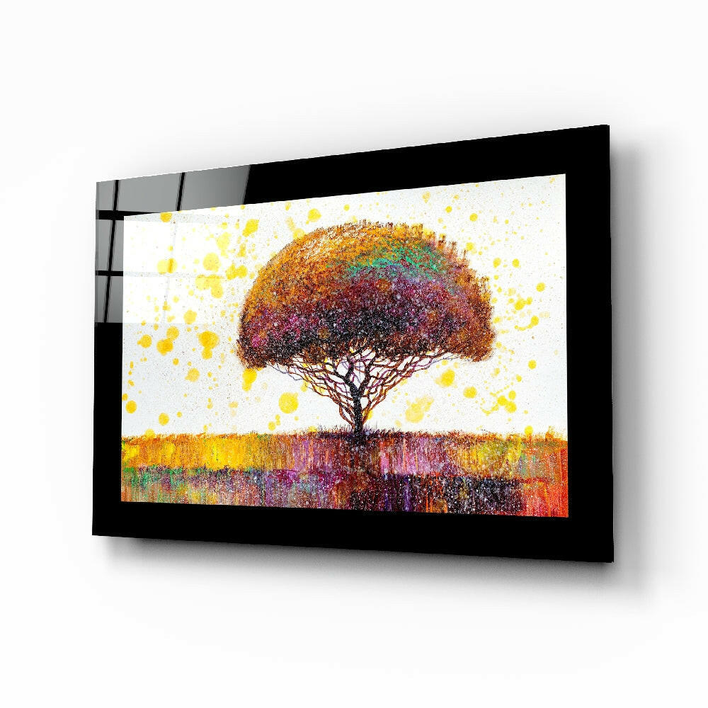 Black-framed glass wall art displaying a colorful tree with vibrant yellow, orange, and purple hues against a white background, viewed at an angle.