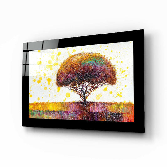 Black-framed glass wall art displaying a colorful tree with vibrant yellow, orange, and purple hues against a white background, viewed at an angle.