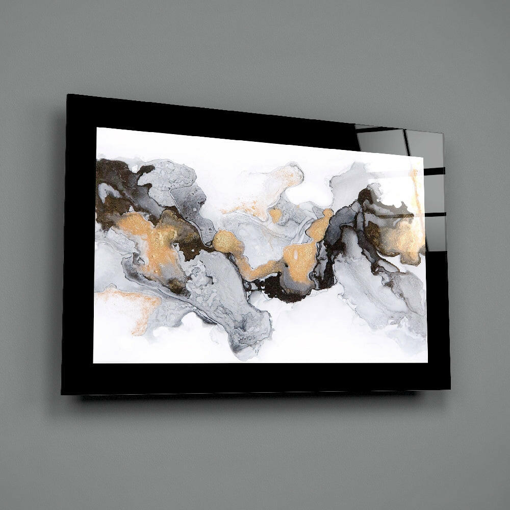 Black-framed glass wall art with abstract marble pattern in gray, gold, and black tones mounted on gray wall.