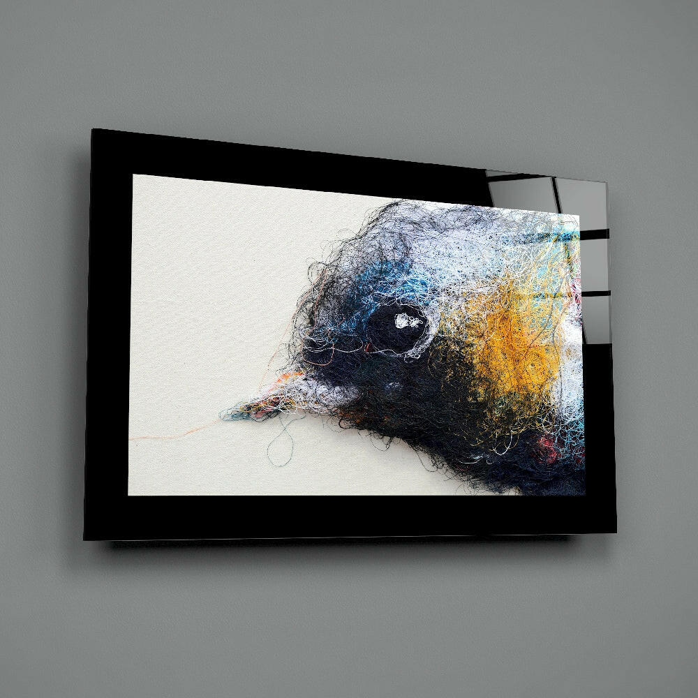 Black-framed glass wall art depicting a stylized bird's head in profile with blue, yellow, and black textured layers against white background.
