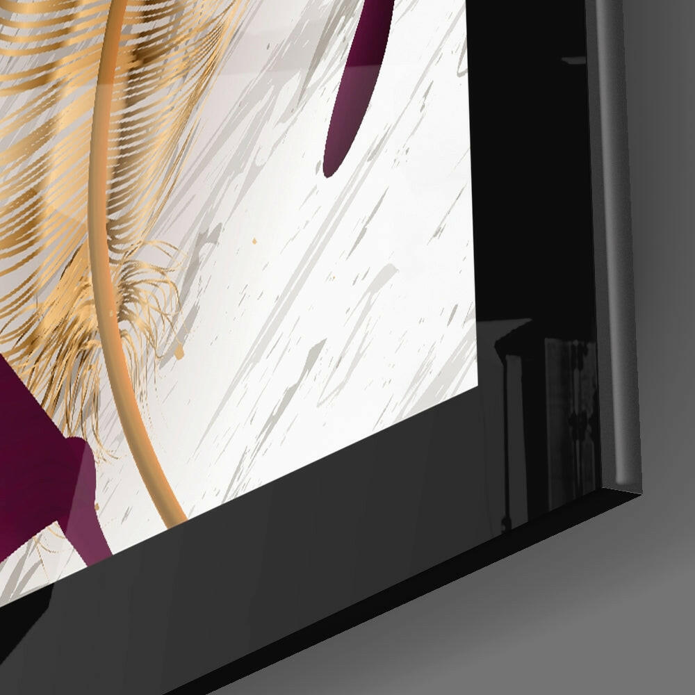 Close-up angled view of glass wall art displaying gold leaf brushstrokes and purple accent against white background, mounted on black frame.