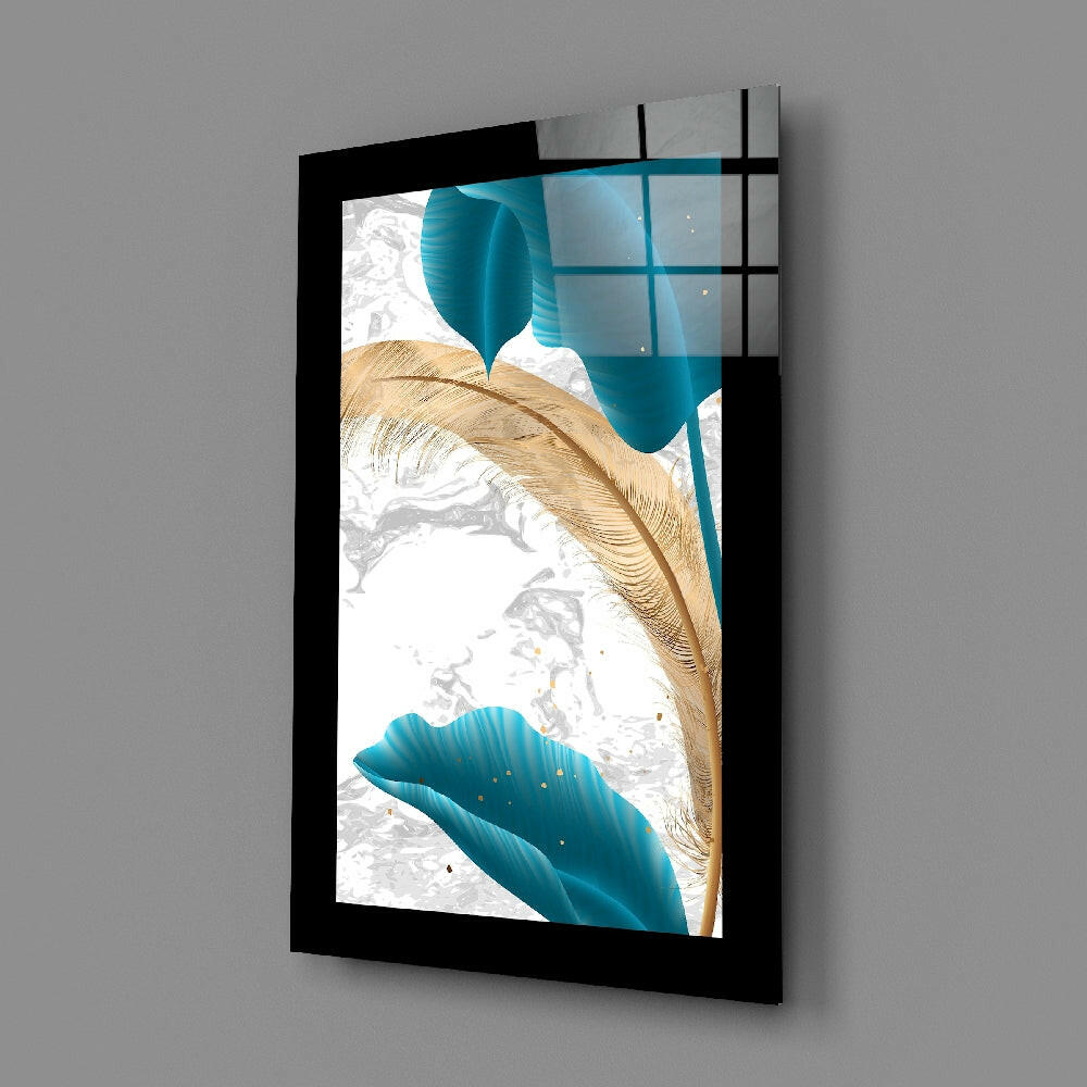 Black-framed glass wall art panel displaying turquoise blue shapes, golden feather, and white marble texture, shown at an angle.