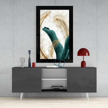 Framed emerald and gold leaf glass art displayed above a gray media console with red decorative accessories in a modern interior setting.