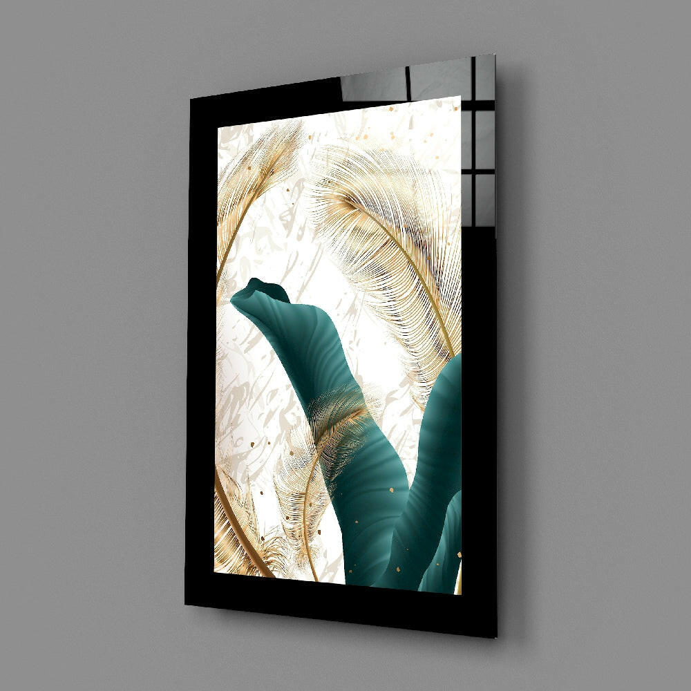 Black-framed glass wall art displaying teal and gold leaf design mounted at an angle against gray wall.
