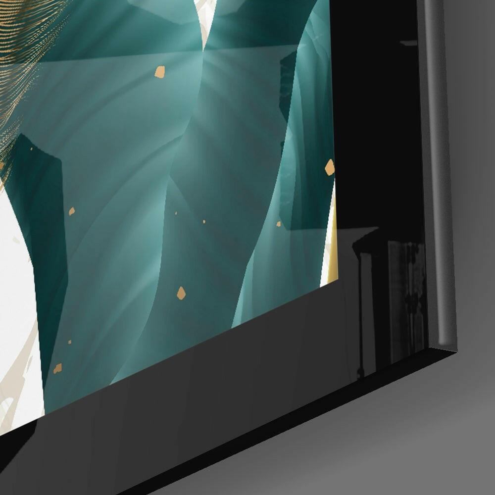 Emerald Leaf Glass Wall Art displayed at an angle against gray wall, showing teal layered leaf design with gold accents and white light behind.
