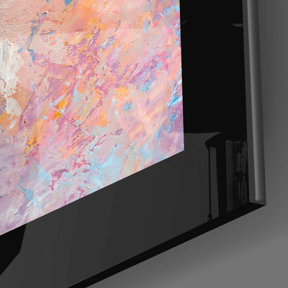 Angled corner view of glass wall art displaying pastel pink, purple, orange, and blue abstract brushstrokes mounted on black stand.