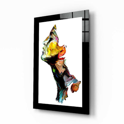 Black-framed glass wall art displaying an abstract vertical composition in vibrant yellows, reds, greens, and blues on white background.