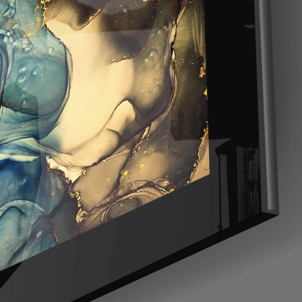 Close-up side angle of glass wall art showing gold leaf accents on blue and cream tones with sculptural figure detail.