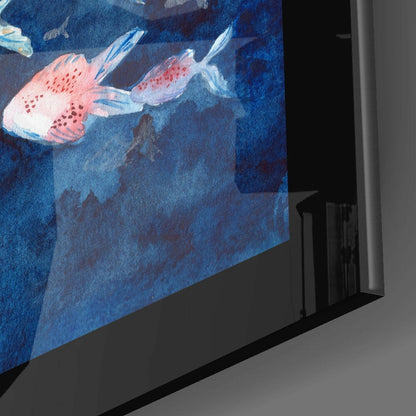 Glass wall art panel displaying two red and white spotted fish swimming in deep blue water, shown at an angle against a gray wall.