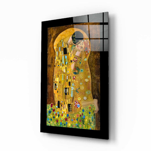 Angled three-quarter view of framed glass art print of Klimt's The Kiss showing golden figures and colorful flowers with black frame and grid pattern overlay.