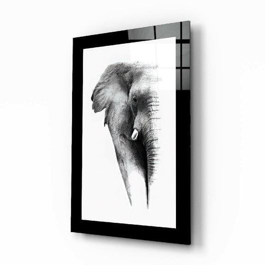 Framed black and white charcoal sketch of an elephant's head in profile, displayed in a black frame mounted on white wall.