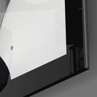 Close-up angled view of white glass panel mounted on black frame showing subtle dust particles and surface texture.